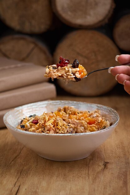 Healthy breakfast concept Oatmeal quinoa granola with yogurt dried fruit seeds honey persimmon in bowl over grey concrete background top view copy space Allergyfriendly gluten free concept