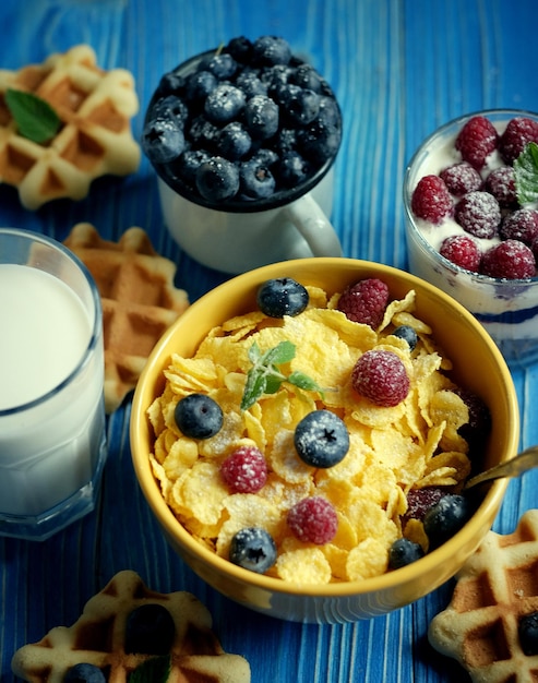 Здоровый завтрак Кукурузные хлопья с малиной и черникой мюсли с йогуртом и ягодами вафли и молоко