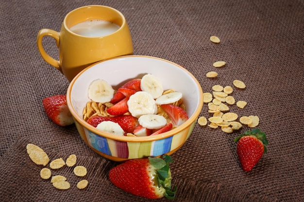 Healthy breakfast Cornflakes fresh strawberries banana and milk