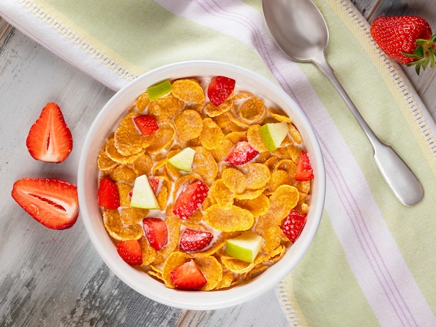 Healthy breakfast cornflakes and strawberries with milk and orange juice. 