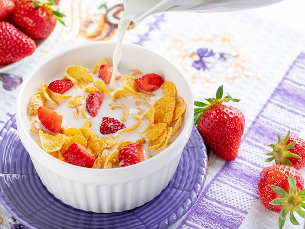 Healthy breakfast cornflakes and strawberries with milk. 