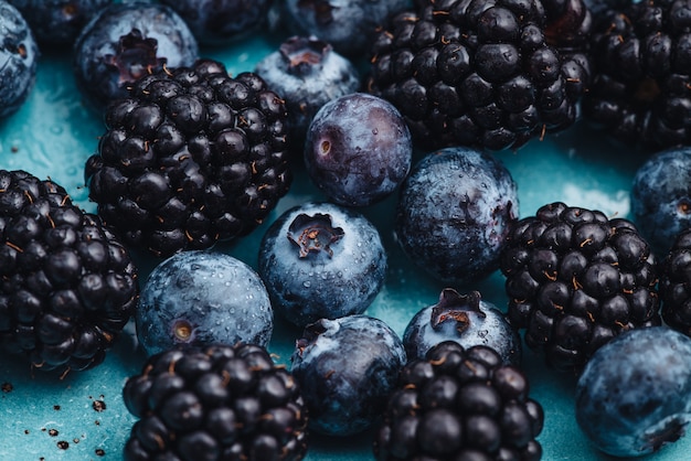 Healthy breakfast eating a mix of fresh blueberries and blackberries