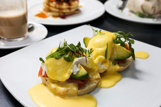 Healthy breakfast Eggs Benedict with salmon and avocado on muffins