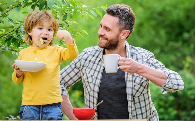 健康的な朝食父の息子は食べ物を食べて楽しんでいます小さな男の子とお父さんは栄養の子供と大人を食べています健康的な栄養の概念子供のためのメニュー栄養習慣家族は自家製の食事を楽しんでいます