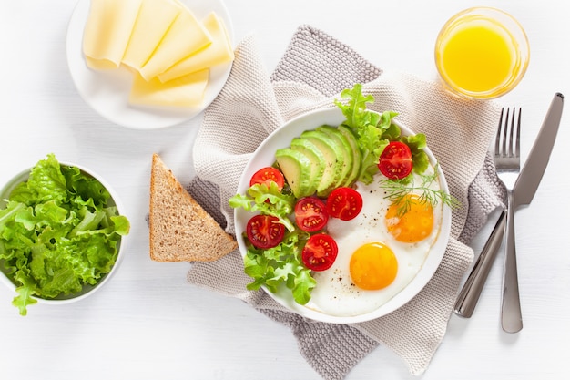 Healthy breakfast flat lay. fried eggs, avocado, tomato, toasts and coffee