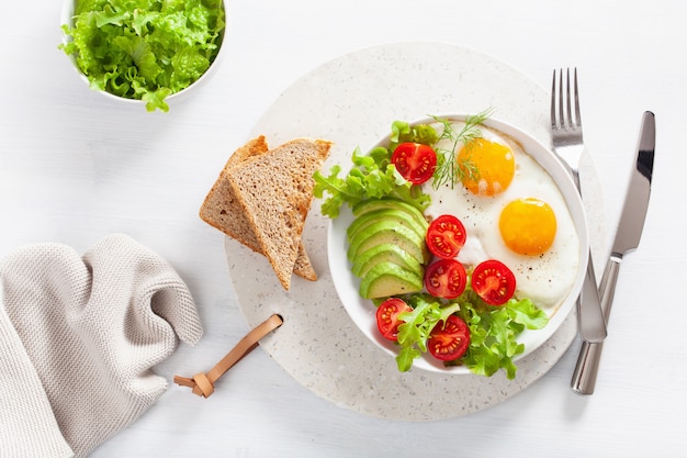 Healthy breakfast flat lay. fried eggs, avocado, tomato, toasts