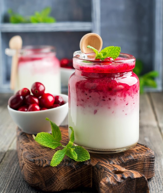 Healthy breakfast. Fresh cranberry smoothie in a glass jar on the old wooden background. Selective focus.