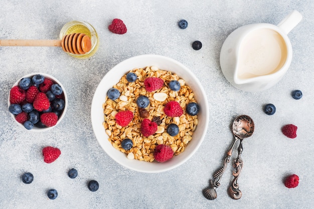 Healthy breakfast. Fresh granola, muesli with yogurt and berries on grey table. Copy space