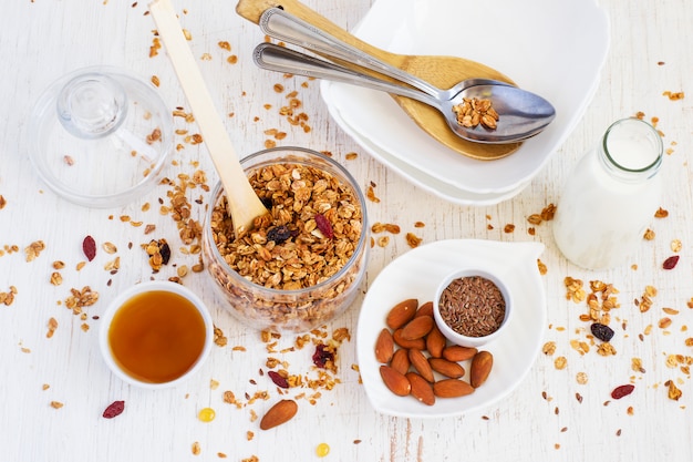 Healthy breakfast. Granola, almonds, milk, honey and a bowl 