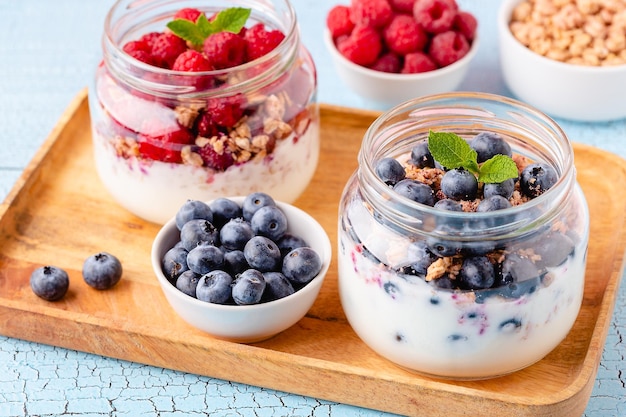 Healthy breakfast Granola muesli yoghurt and fruit served in glass jars