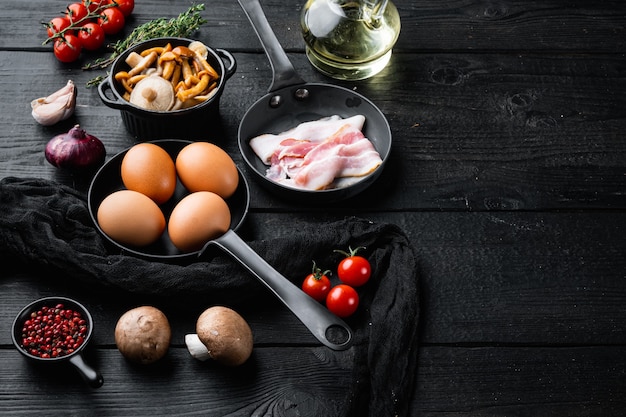 目玉焼きの健康的な朝食の材料セット、黒い木製のテーブルの背景、テキストコピースペース