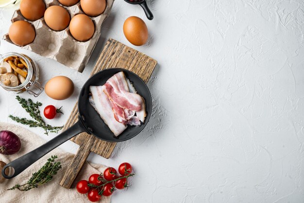 Healthy breakfast ingredients for fried eggs on white background top view flat lay with space for text copyspace