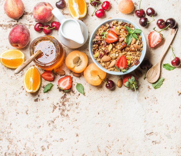 Photo healthy breakfast ingredients oat granola in bowl with nuts strawberry and mint