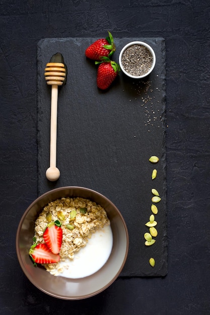 건강한 아침 식사 재료:오트밀, 꿀, 딸기, 치아 씨앗 커팅 보드.복사 공간이 있는 위쪽 전망. 천연 유기농 식품의 개념입니다.