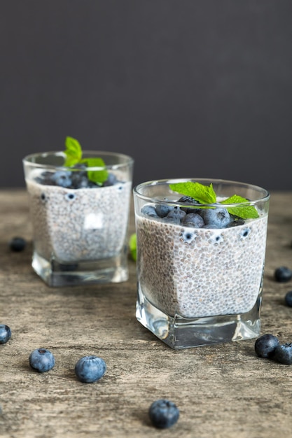 Sana colazione o mattina con semi di chia budino alla vaniglia e bacche di mirtillo su sfondo tavolo dieta vegetariana e concetto di salute budino di chia con latte di cocco e mirtillo