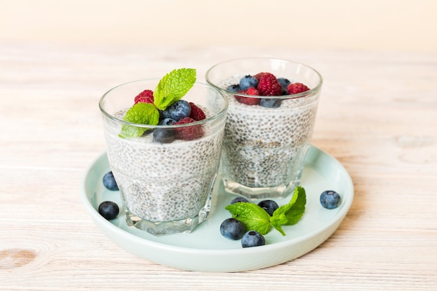 Healthy breakfast or morning with chia seeds vanilla pudding raspberry and blueberry berries on table background vegetarian food diet and health concept Chia pudding with raspberry and blueberry