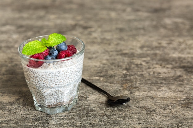 Healthy breakfast or morning with chia seeds vanilla pudding raspberry and blueberry berries on table background vegetarian food diet and health concept Chia pudding with raspberry and blueberry