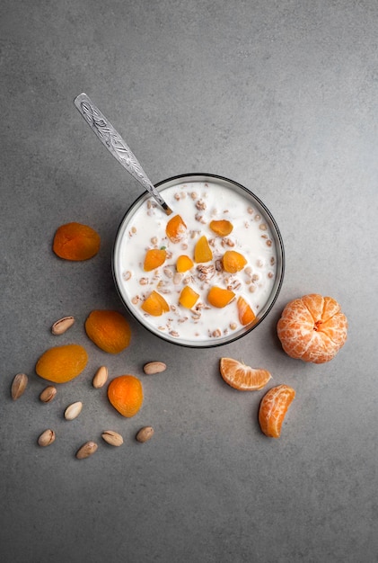 Foto sana colazione a base di muesli con frutta fresca e yogurt su un tavolo grigio