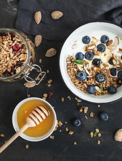 Healthy breakfast Oat granola with fresh blueberries almond yogurt and mint in a rustic metal bowl