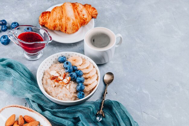 Prima colazione sana - farina d'avena, croissant e caffè