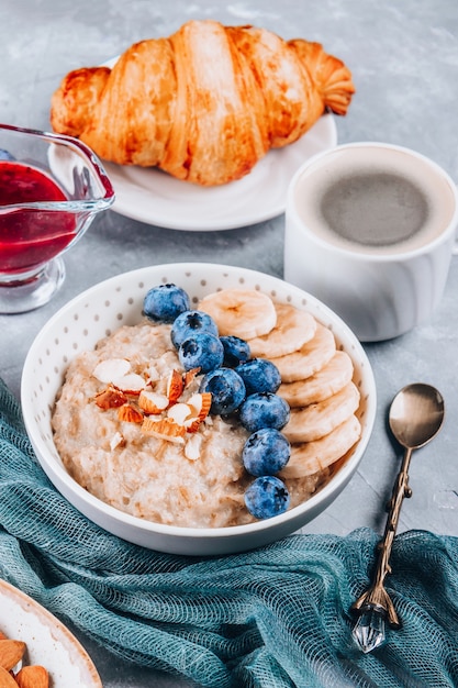 Healthy breakfast - oatmeal, croissant and coffee