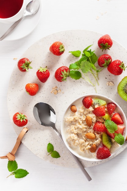 Healthy breakfast oatmeal porridge, strawberry, nuts. Top view