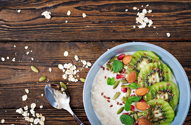 Healthy breakfast. Oatmeal with kiwi, pomegranate, flax seeds and nuts. Detox menu. Top view. Flat lay