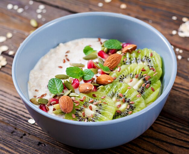 Healthy breakfast. Oatmeal with kiwi, pomegranate, flax seeds and nuts. Detox menu.