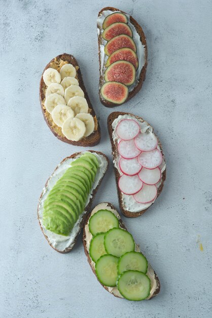 Healthy breakfast sandwiches with avocado, cucumber, fig fruit, banana, cream cheese.