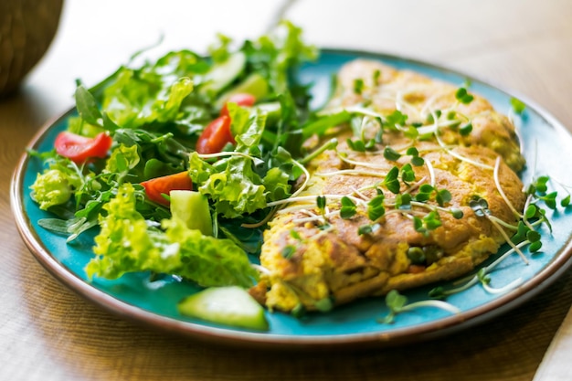 healthy breakfast of scrambled eggs with green vegetables