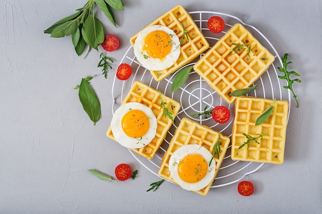 Healthy breakfast - waffles, eggs, tomatoes and herbs. Flat lay. Top view