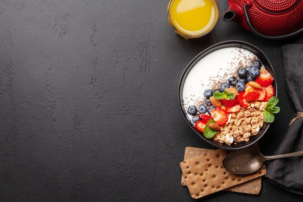 Здоровый завтрак с миской йогурта мюсли и свежими ягодами