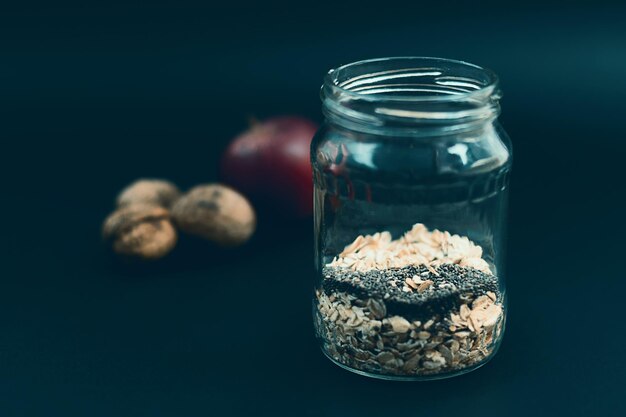 Healthy breakfast with chia seeds. Apple nut overnight oats and chia, in glass jar. Preparation overnight breakfast with flakes of oats, chia, apple, nuts.