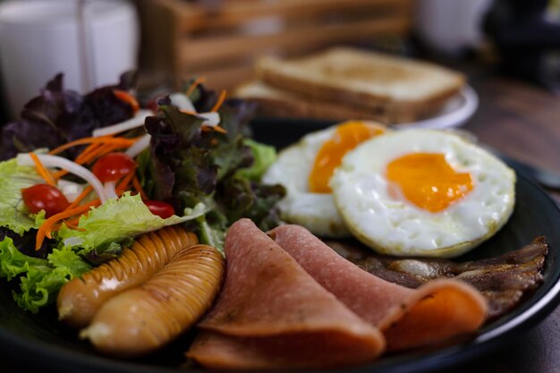 Foto una colazione sana con verdure fresche, insalata biologica, uova fritte e salsicce.