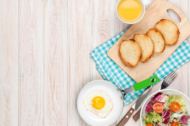 Healthy breakfast with fried egg toasts and salad