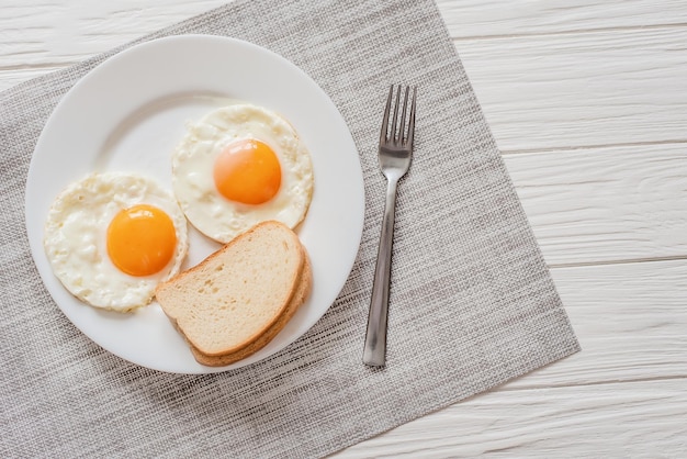 Healthy breakfast with fried eggs on wooden table