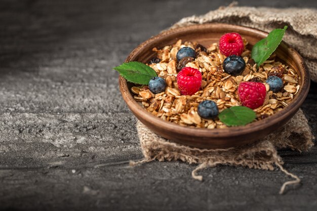 Фото Здоровый завтрак с мюсли и ягоды на темном фоне.