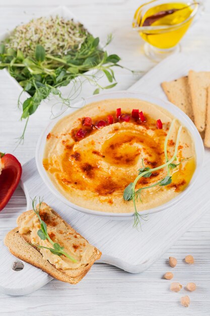 Healthy breakfast with homemade hummus on white wooden surface. Diet and Healthy snack food.