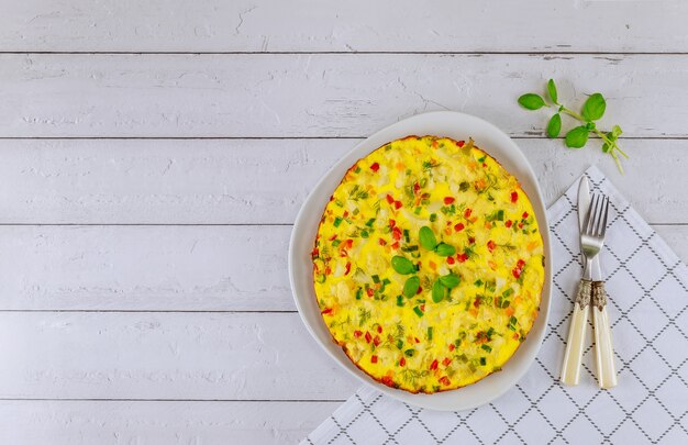 Healthy breakfast with vegetable omelette on white wooden.