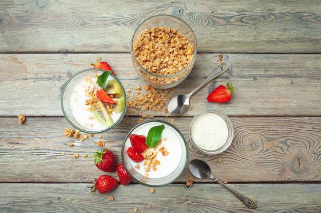 Здоровый завтрак с йогуртом, ягодами и мюсли на вид сверху деревянный стол