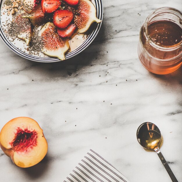 Healthy breakfast with yogurt fruits and honey square crop