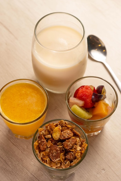 Sana colazione con yogurt, muesli, frutta e succo d'arancia.