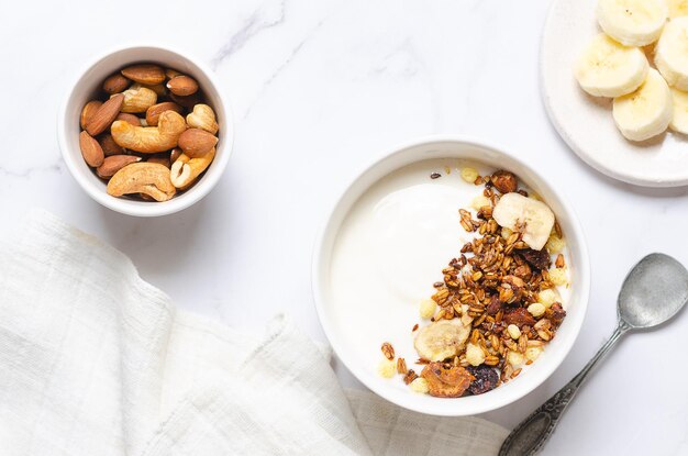 Healthy breakfast with yogurt granola and nuts on white background