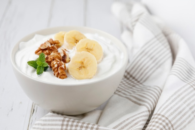 Healthy breakfast of yogurt with banana, walnuts and cinnamon