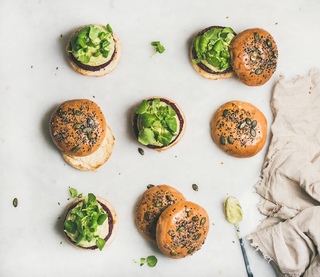 Healthy burgers with beetroot patties and green sprouts top view