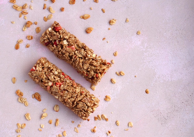 Healthy cereal bar with granola on a pinklilac background