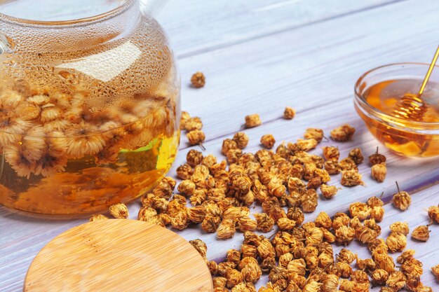 Healthy chamomile tea  in glass cup. Teapot, small honey jar