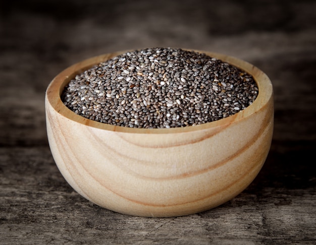 Healthy Chia seeds in bowl on wooden.