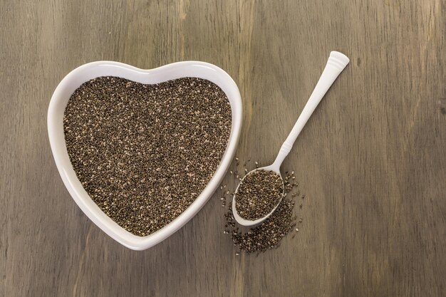 Healthy Chia seeds in a heart shape bowl close-up.