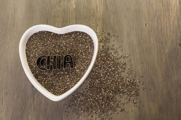 Healthy Chia seeds in a heart shape bowl close-up.